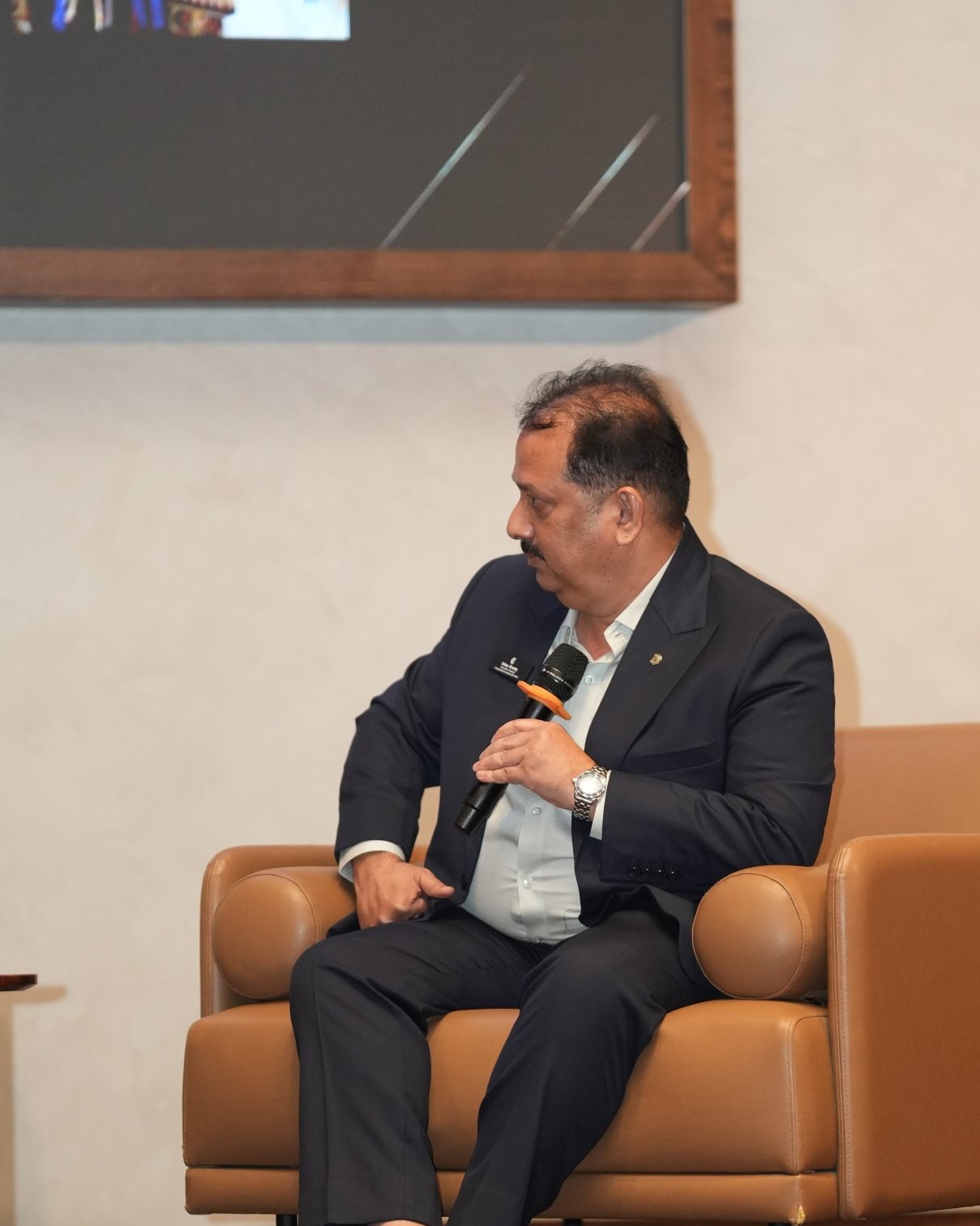 Uday Shetty seated on stage with a microphone during a CC Hyderabad 4 fireside chat