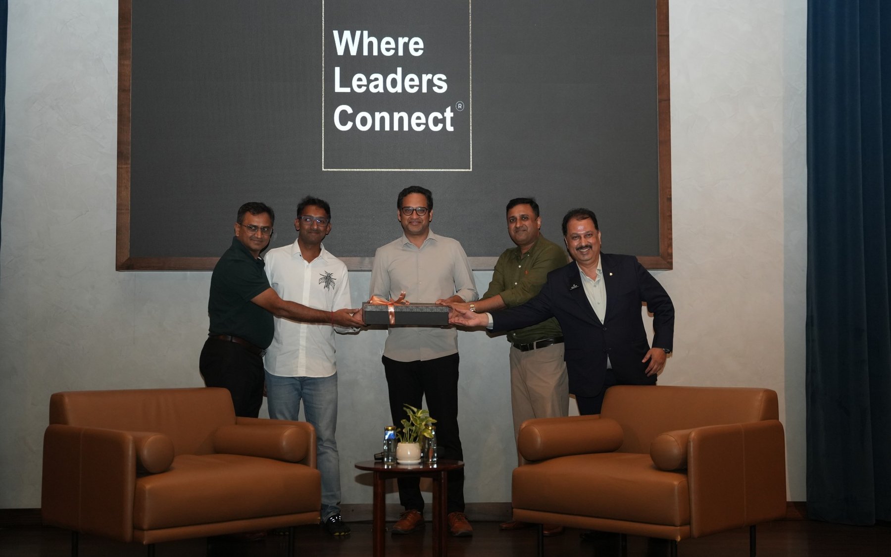 Uday Shetty with leaders on stage under Where Leaders Connect backdrop