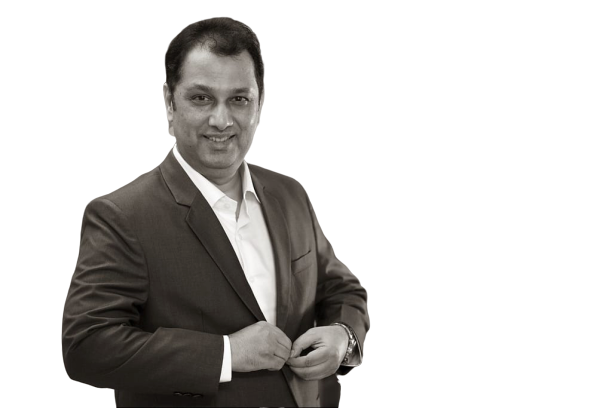 Uday Shetty in a dark coat, studio portrait on black background